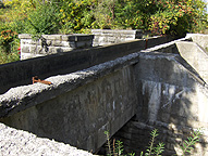 The narrow channel which feeds water to the canal, looking southwest